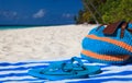 Straw bag, towel and flip flops on a tropical beach Royalty Free Stock Photo