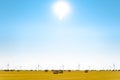 Straw Bales on the Bright Yellow Field under Blue Sky. Wind Generator Turbines on the Background Royalty Free Stock Photo