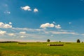 Straw bales on farmland. Harvest in countryside. Reap cereal plantation. Autumn field with cloudy blue sky, Czech countryside. Royalty Free Stock Photo