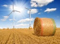 Straw bales on farmland with wind turbine