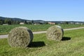 Straw bales in the field collecting during harvesting in Switzerland countryside during sunny day Royalty Free Stock Photo