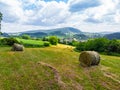 Straw bales on the field near Saschiz fortified church in Saschiz villages, Sibiu, Transylvania, Romania. Agriculture landscape, g Royalty Free Stock Photo