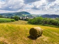 Straw bales on the field near Saschiz fortified church in Saschiz villages, Sibiu, Transylvania, Romania. Agriculture landscape, g Royalty Free Stock Photo