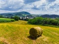 Straw bales on the field near Saschiz fortified church in Saschiz villages, Sibiu, Transylvania, Romania. Agriculture landscape, g Royalty Free Stock Photo