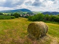 Straw bales on the field near Saschiz fortified church in Saschiz villages, Sibiu, Transylvania, Romania. Agriculture landscape, g Royalty Free Stock Photo