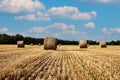 Straw bales on the field under blue sky with white clouds Royalty Free Stock Photo