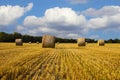 Straw bales on the field under blue sky with white clouds Royalty Free Stock Photo