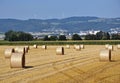 Straw bales in the field under ÃÂ ternberk, on the horizon of a wind turbine. Czech Republic.