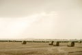 Straw bales on a rainy overcast day. View through a car window with rain drops on it. Harvest in wet and bead weather Royalty Free Stock Photo