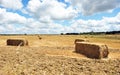 Straw bales stacked in a field of grain harvested Royalty Free Stock Photo