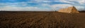 panoram of straw bales stacked in a pyramid shaped pile on a plowed field, arable land Royalty Free Stock Photo