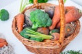 Straw Basket with garden Vegetables - fresh carrots, beets, broccoli, onions on the white wooden background. Farm Harvest. Food or Royalty Free Stock Photo