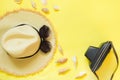 Straw beach foman`s hat, black sun glasses with retro camera on yellow background. Top view. Flat lay. Space for text. Travel con