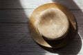 Straw beach hat with brims for sun protection on wooden boards.