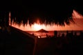 Straw beach roof in the cafe with blurred people on coral sunset.