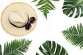 Straw beach sun hat with sunglasses,border of tropical monstera and fern on white. Top view, copy space. Summer concept