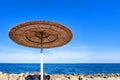 straw beach umbrella against the background of the sea horizon and a clear blue sky, copy space Royalty Free Stock Photo