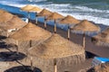 Straw beach umbrellas along a beautiful shoreline at dusk