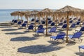 Straw beach umbrellas and sun chairs on a sandy beach on the east coast of Zakynthos island, Greece Royalty Free Stock Photo