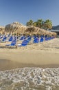 Straw beach umbrellas and sun chairs on a sandy beach on the east coast of Zakynthos island, Greece Royalty Free Stock Photo