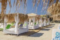 Straw beach umbrellas and sun chairs on a sandy beach on the east coast of Zakynthos island, Greece Royalty Free Stock Photo