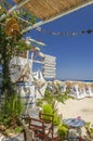 Straw beach umbrellas and sun chairs on a sandy beach on the east coast of Zakynthos island, Greece Royalty Free Stock Photo