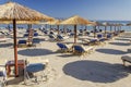 Straw beach umbrellas and sun chairs on a sandy beach on the east coast of Zakynthos island, Greece Royalty Free Stock Photo