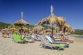 Straw beach umbrellas and sun chairs on a sandy beach on the east coast of Zakynthos island, Greece Royalty Free Stock Photo