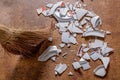 Pieces of shattered dishes. Fragments of the broken white ware on the floor.