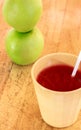 Straw in cup of juice and blur apple ,wood background.