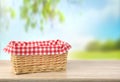 Straw empty basket decorated with picnic checkered cloth  nature background Royalty Free Stock Photo