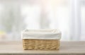 Straw empty basket with white linen on table
