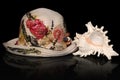 Straw flowery hat and a murex sea shell Royalty Free Stock Photo