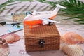 Straw gift box and a plane on it with seashells  palm leaves and polaroid photos on wooden background. Summer beach and travel Royalty Free Stock Photo