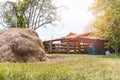 Straw on green grass near animals fence at countryside