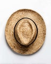 A close up shot of a straw hat with a black band on a white background from a top down perspective Royalty Free Stock Photo