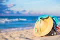 Straw hat and blue bikini bra swimsuit with beach bag against the ocean beach with beautiful blue sky and clouds. Relaxation, Royalty Free Stock Photo