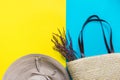 Straw hat with bow wicker handwoven beach bag with lavender twigs on bright yellow mint blue duotone background. Travel vacation Royalty Free Stock Photo