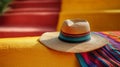 Straw hat on colorful Mexican textile and yellow wall Royalty Free Stock Photo