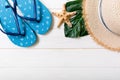 Straw hat, green leaf, blue flip flops and starfish On a white wooden background. top view summer holiday concept with copy space Royalty Free Stock Photo