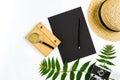 Straw hat with green leaves and old camera on white background, Summer background. Top view Royalty Free Stock Photo