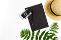 Straw hat with green leaves and old camera on white background, Summer background. Top view Royalty Free Stock Photo