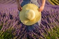 Straw hat in the hands of a girl in a lavender field