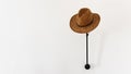 Straw hat hanging on wall stand on a white wall. Banner, copy space