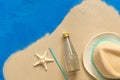 Straw hat, papaya juice and starfish on the sea sand, blue painted background. Travel and beach vacation concept. Top view, flat Royalty Free Stock Photo