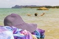Straw hat and pareo are lying on a stone against the background of a woman drowning in the sea and calling for help Royalty Free Stock Photo