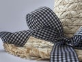 Straw hat with a ribbon on a gray background.