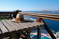 Straw hat with sun glasses on wooden terrace of holiday villa or hotel with chair table with sea and swimming pool view Royalty Free Stock Photo