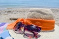 Straw hat, sunglasses and a book on the beach with sea in backgo Royalty Free Stock Photo