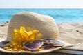 Straw hat, sunglasses and a book on the beach. Summer vacation a Royalty Free Stock Photo